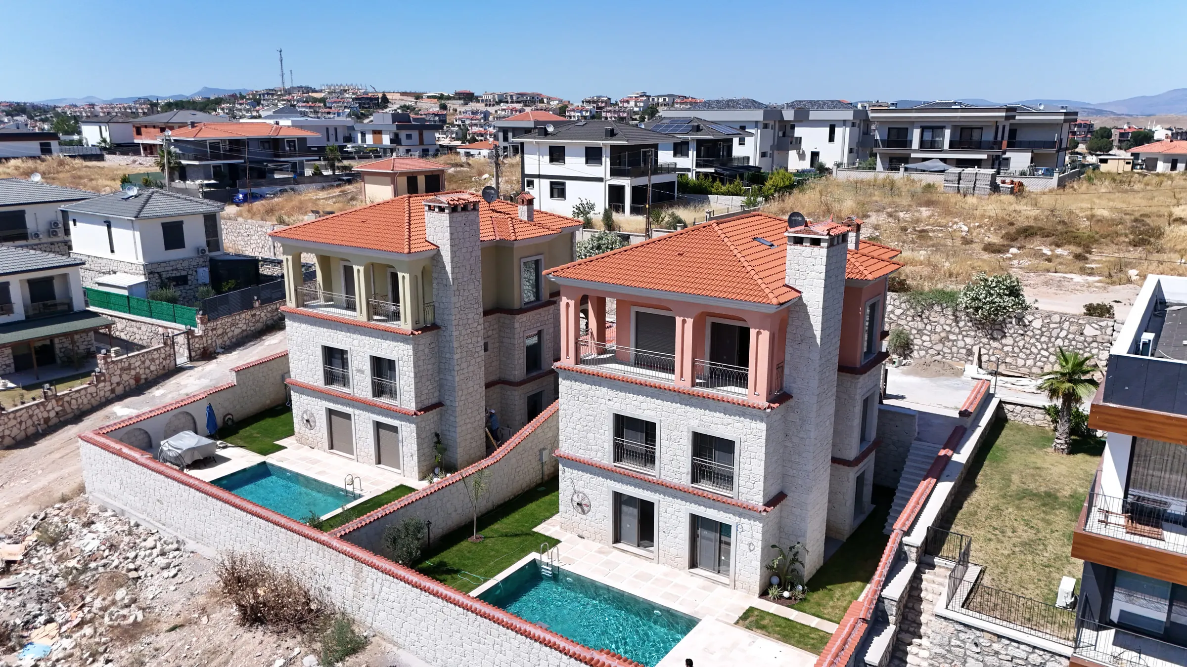 Tamamlanmış Taşmahal villalarının havadan görünümü: taş cepheler, kiremit çatılar ve özel havuzlar